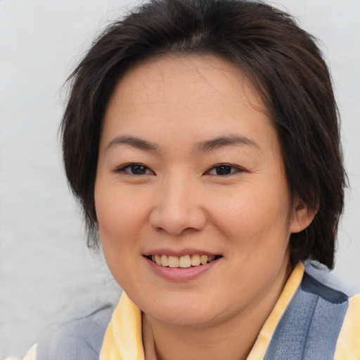 Joyful asian young-adult female with medium  brown hair and brown eyes