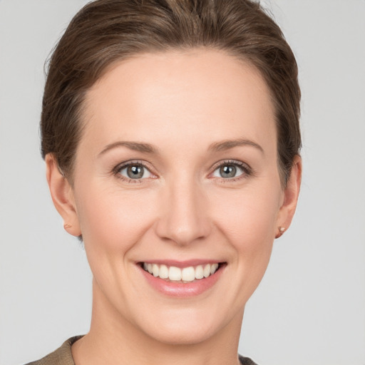 Joyful white young-adult female with short  brown hair and grey eyes