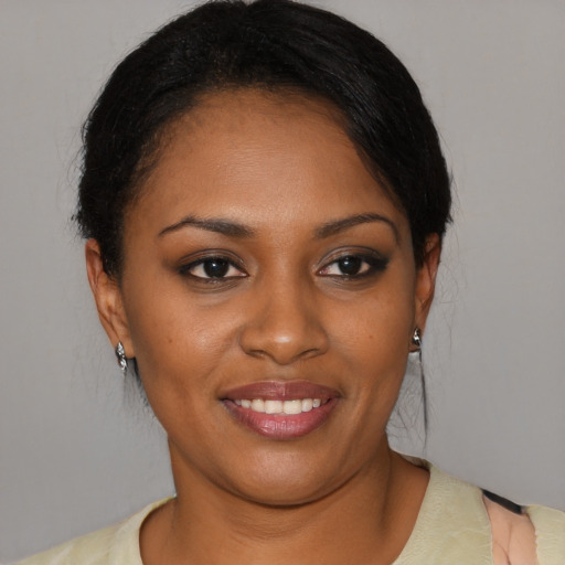 Joyful black young-adult female with short  black hair and brown eyes