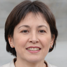 Joyful white adult female with medium  brown hair and brown eyes