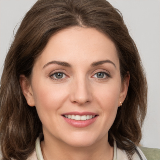 Joyful white young-adult female with medium  brown hair and grey eyes