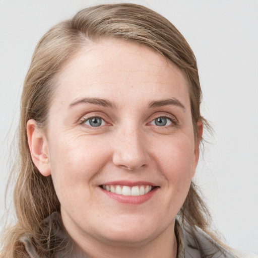 Joyful white young-adult female with long  brown hair and blue eyes