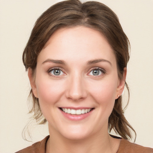 Joyful white young-adult female with medium  brown hair and green eyes