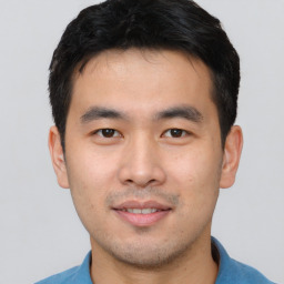 Joyful asian young-adult male with short  black hair and brown eyes