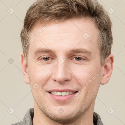 Joyful white adult male with short  brown hair and grey eyes