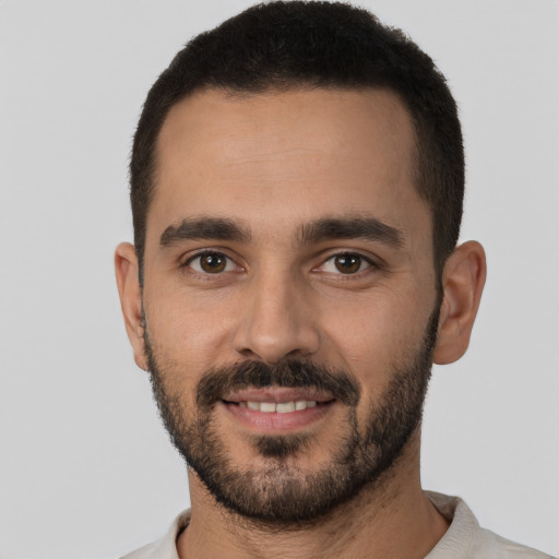 Joyful white young-adult male with short  black hair and brown eyes