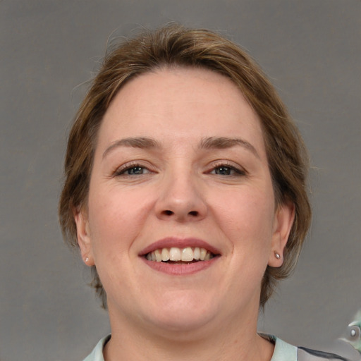 Joyful white adult female with medium  brown hair and grey eyes