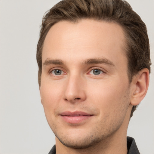 Joyful white young-adult male with short  brown hair and grey eyes