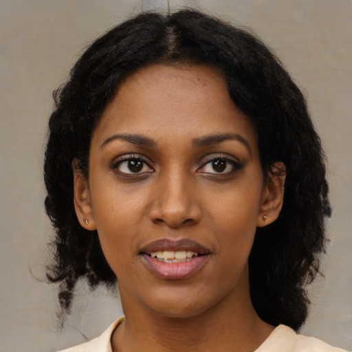 Joyful black young-adult female with medium  black hair and brown eyes