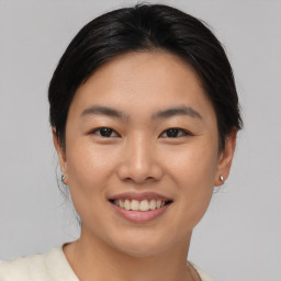 Joyful asian young-adult female with short  brown hair and brown eyes