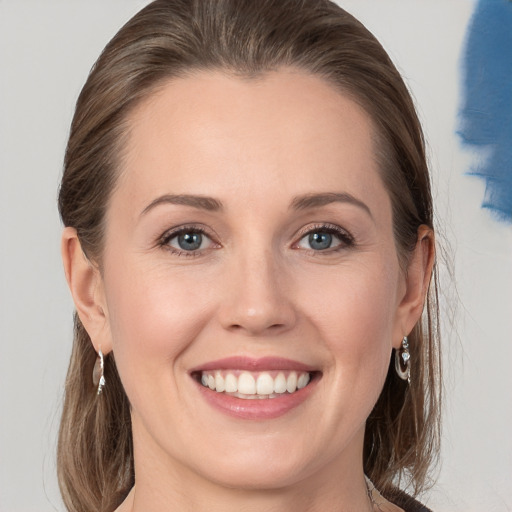 Joyful white young-adult female with medium  brown hair and grey eyes