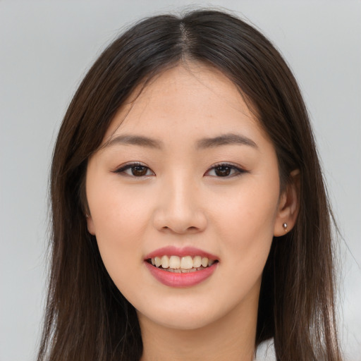 Joyful asian young-adult female with long  brown hair and brown eyes