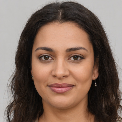 Joyful latino young-adult female with long  brown hair and brown eyes