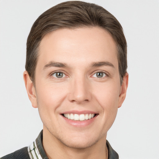 Joyful white young-adult male with short  brown hair and grey eyes