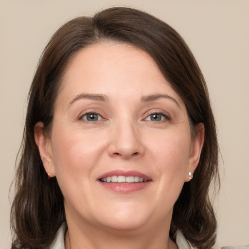 Joyful white adult female with medium  brown hair and grey eyes