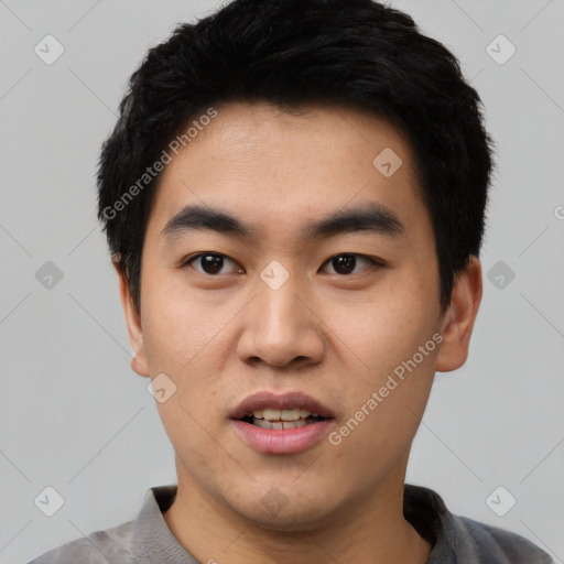 Joyful asian young-adult male with short  black hair and brown eyes