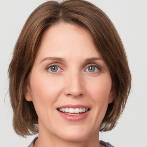 Joyful white young-adult female with medium  brown hair and green eyes