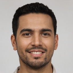 Joyful latino young-adult male with short  black hair and brown eyes