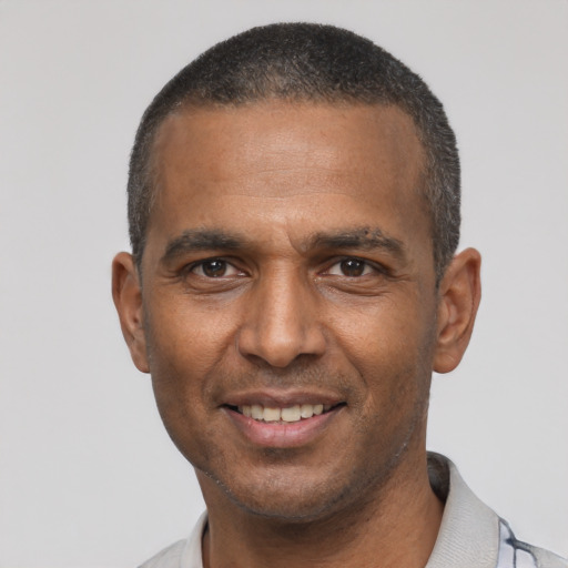 Joyful latino adult male with short  black hair and brown eyes
