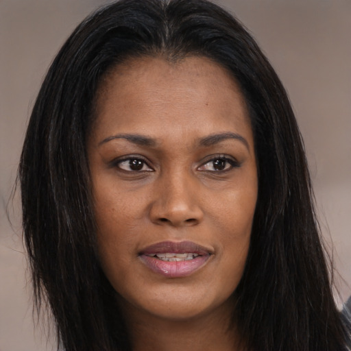 Joyful black young-adult female with long  brown hair and brown eyes