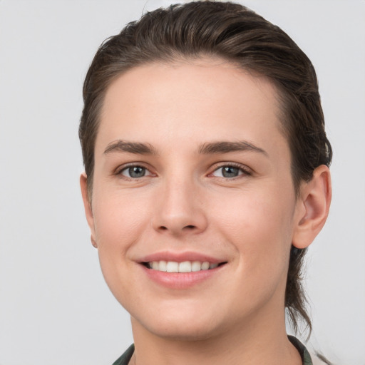 Joyful white young-adult female with short  brown hair and grey eyes