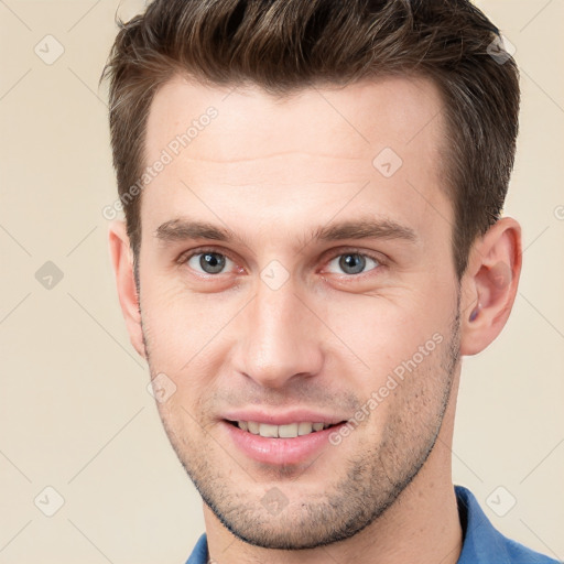 Joyful white young-adult male with short  brown hair and grey eyes