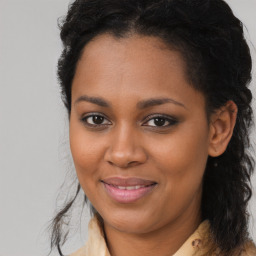 Joyful black young-adult female with long  brown hair and brown eyes