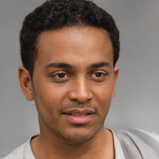 Joyful black young-adult male with short  black hair and brown eyes