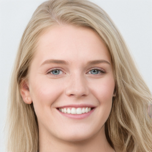 Joyful white young-adult female with long  brown hair and blue eyes