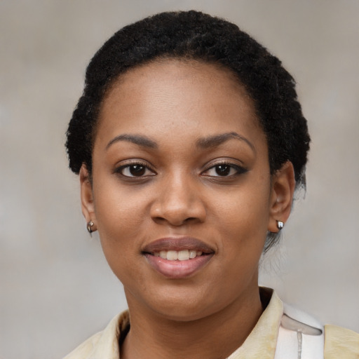 Joyful black young-adult female with short  black hair and brown eyes