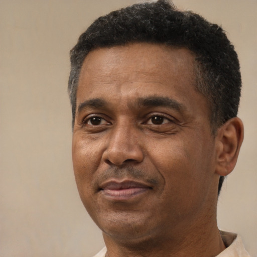 Joyful black adult male with short  black hair and brown eyes