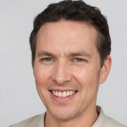 Joyful white adult male with short  brown hair and brown eyes