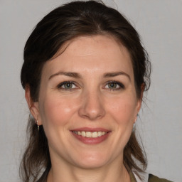 Joyful white adult female with medium  brown hair and grey eyes