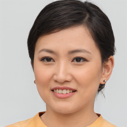 Joyful asian young-adult female with medium  brown hair and brown eyes