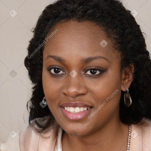 Joyful black young-adult female with long  brown hair and brown eyes