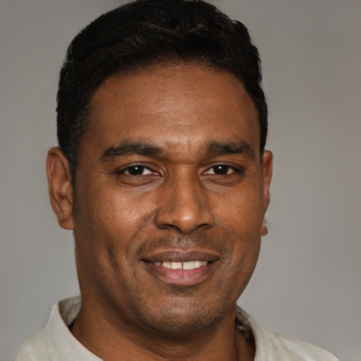 Joyful latino adult male with short  brown hair and brown eyes