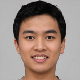 Joyful asian young-adult male with short  black hair and brown eyes