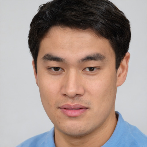 Joyful asian young-adult male with short  brown hair and brown eyes