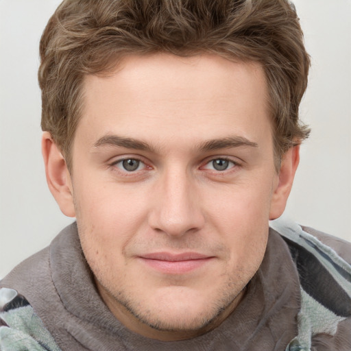 Joyful white young-adult male with short  brown hair and blue eyes