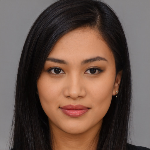 Joyful latino young-adult female with long  brown hair and brown eyes