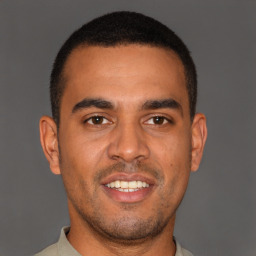 Joyful latino young-adult male with short  brown hair and brown eyes