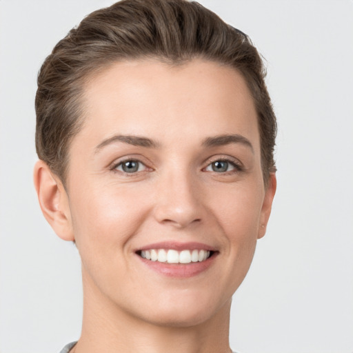 Joyful white young-adult female with short  brown hair and grey eyes