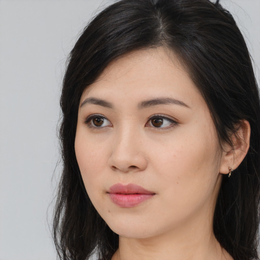 Joyful asian young-adult female with long  brown hair and brown eyes