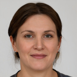 Joyful white adult female with medium  brown hair and grey eyes