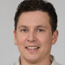 Joyful white adult male with short  brown hair and grey eyes