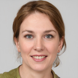 Joyful white young-adult female with medium  brown hair and grey eyes