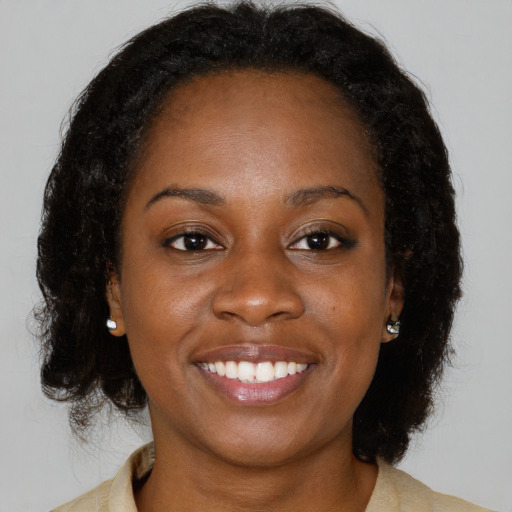 Joyful black young-adult female with medium  brown hair and brown eyes