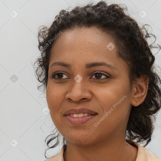 Joyful black young-adult female with long  brown hair and brown eyes