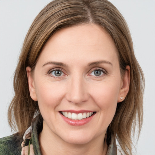 Joyful white young-adult female with medium  brown hair and grey eyes