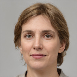 Joyful white adult female with medium  brown hair and grey eyes